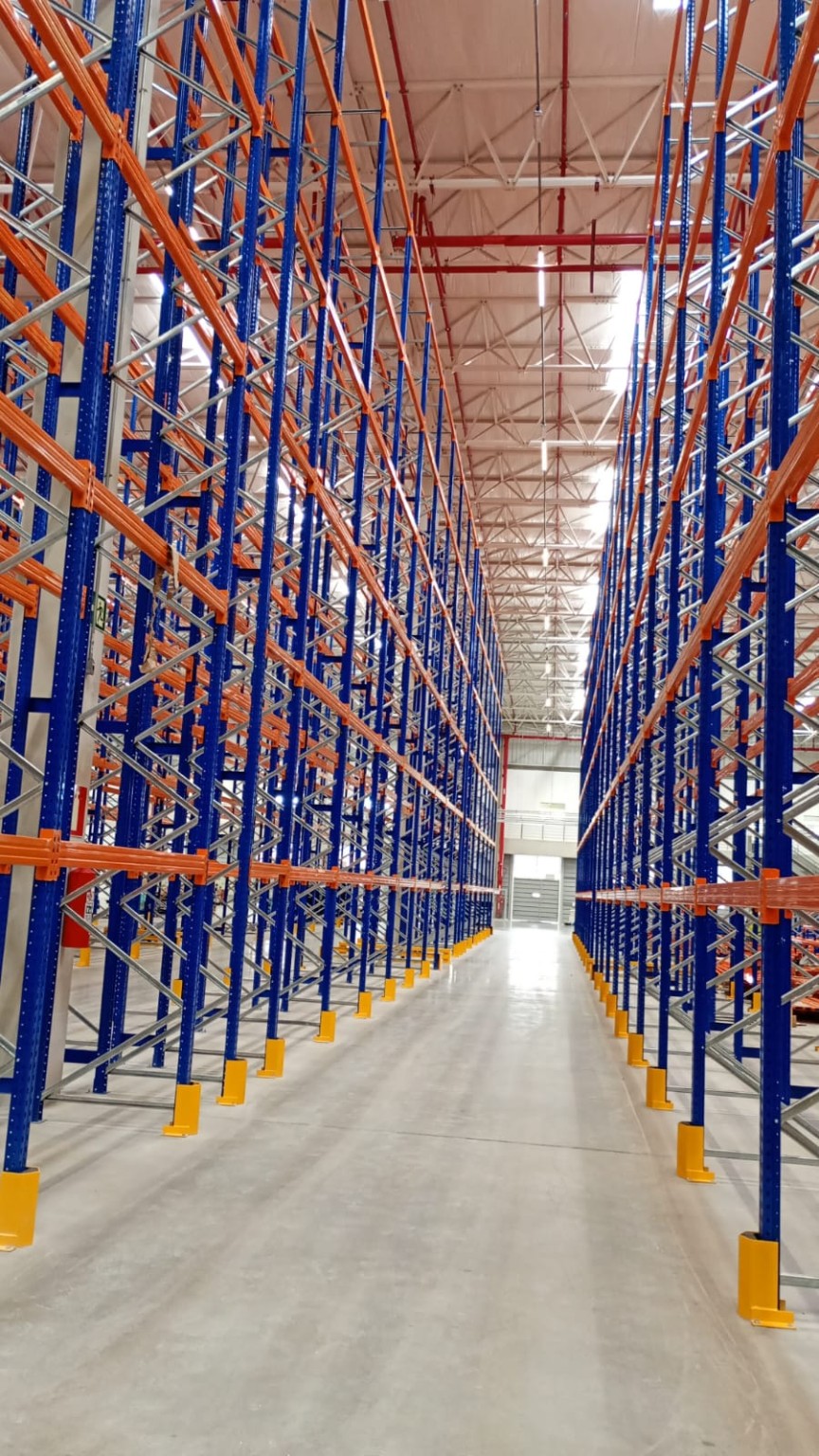 Corredor com estruturas porta-pallets altas em azul e laranja